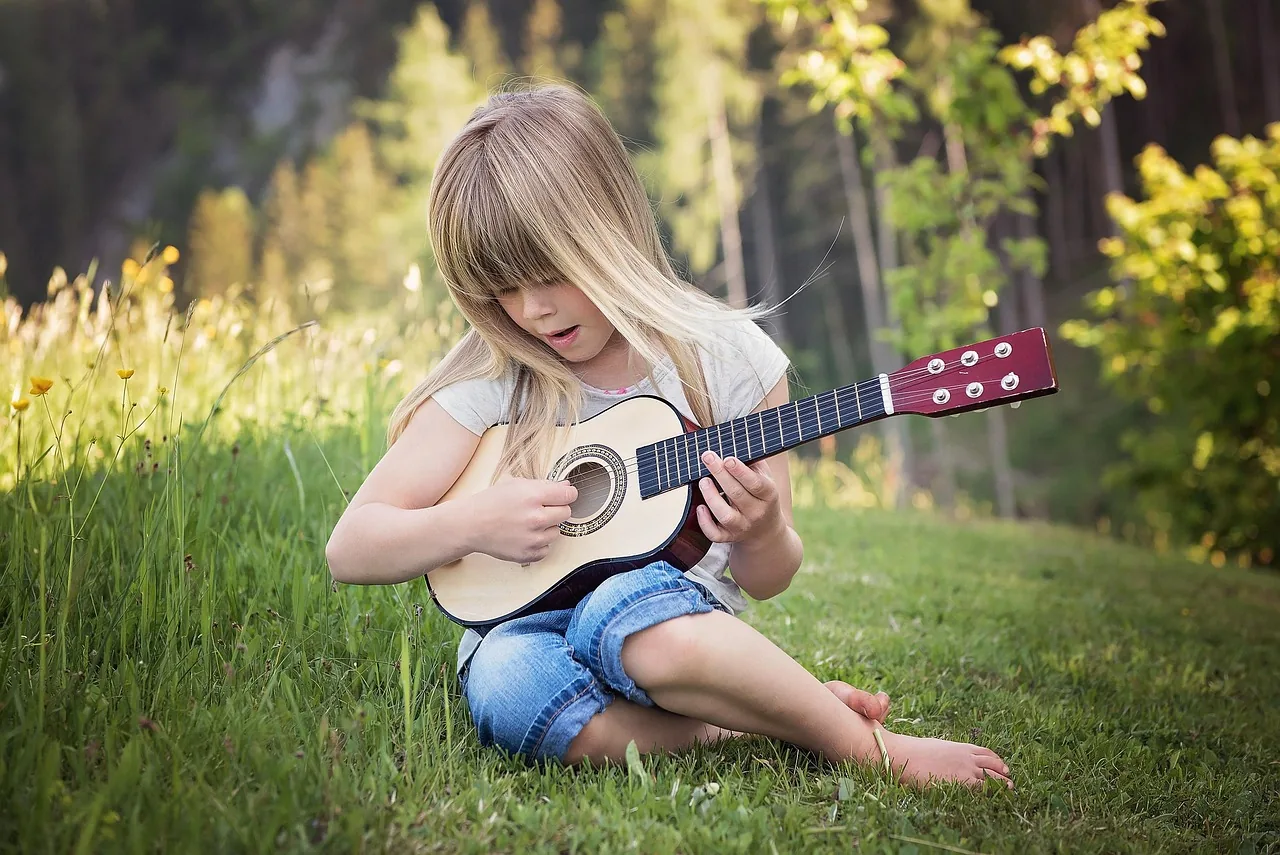 Enfant découvrant la guitare acoustique folk Enfant découvrant la guitare acoustique folk