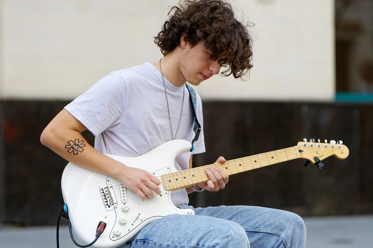 Jeune musicien apprenant à jouer guitare